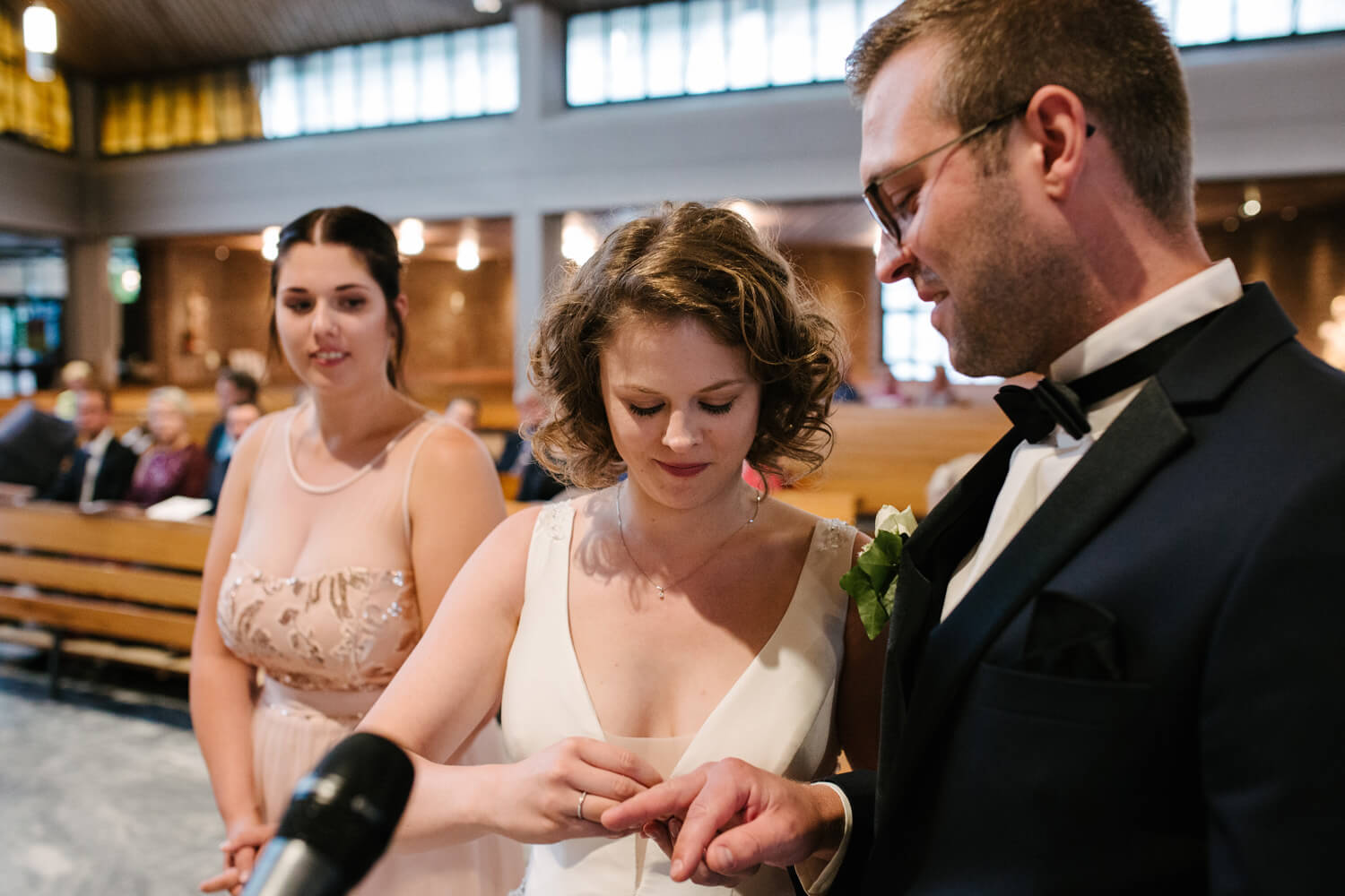 Braut steckt dem Bräutigam den Ehering an.